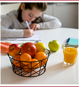 School girl doing school work from kitchen table at home