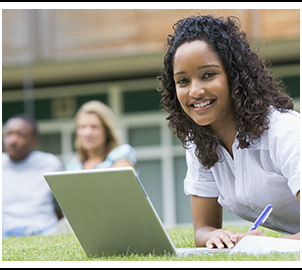 Happy high school student studying outside with laptop